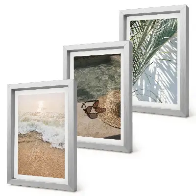 Gallery wall met afbeelding van een strandhoed en zonnebril tussen bladeren